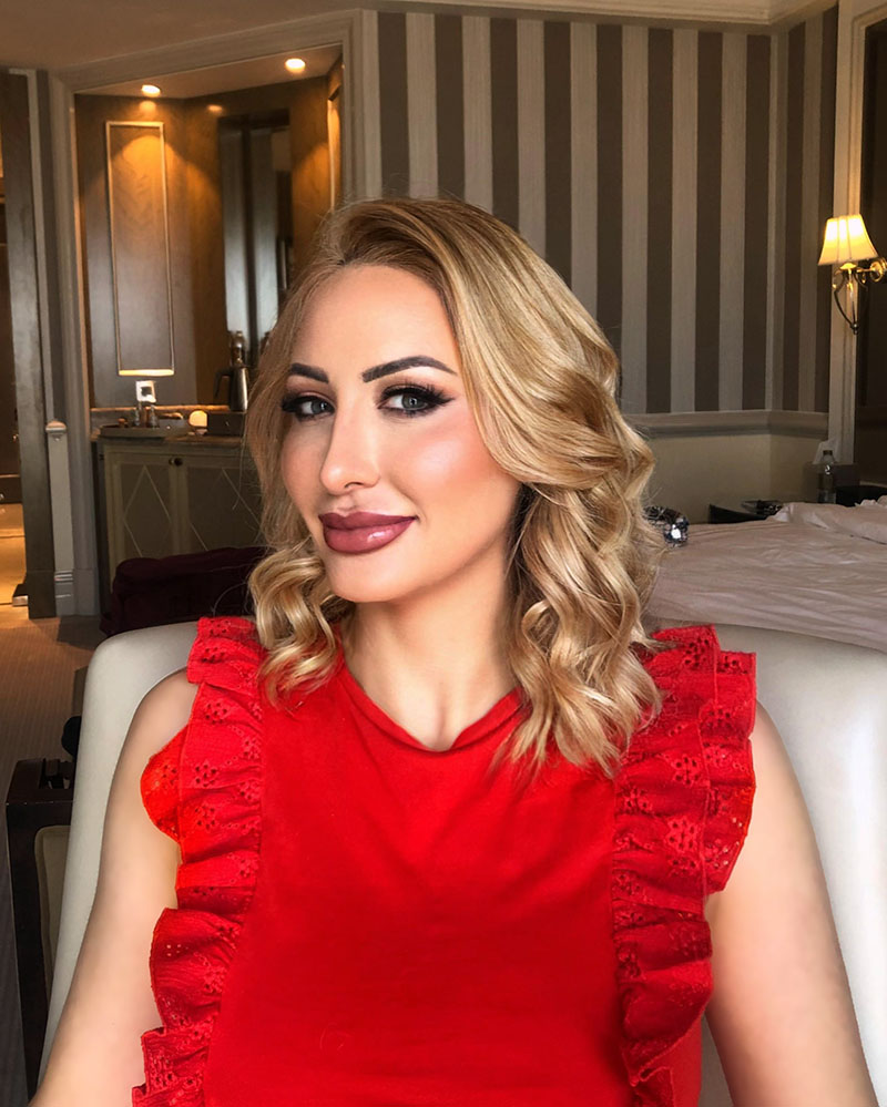 High Class Independent Escort Joelle Monroe Joelle Monroe in a red top in a hotel room.