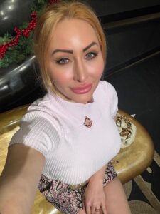Joelle Monroe self-portrait, wearing a white top.